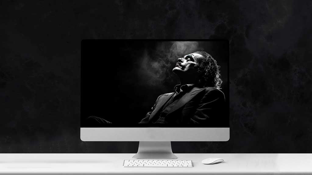 fond écran artistique du Joker en noir et blanc présentant une silhouette de profil dramatique en costume avec des effets de fumée, disponible en résolution HD et 4K.