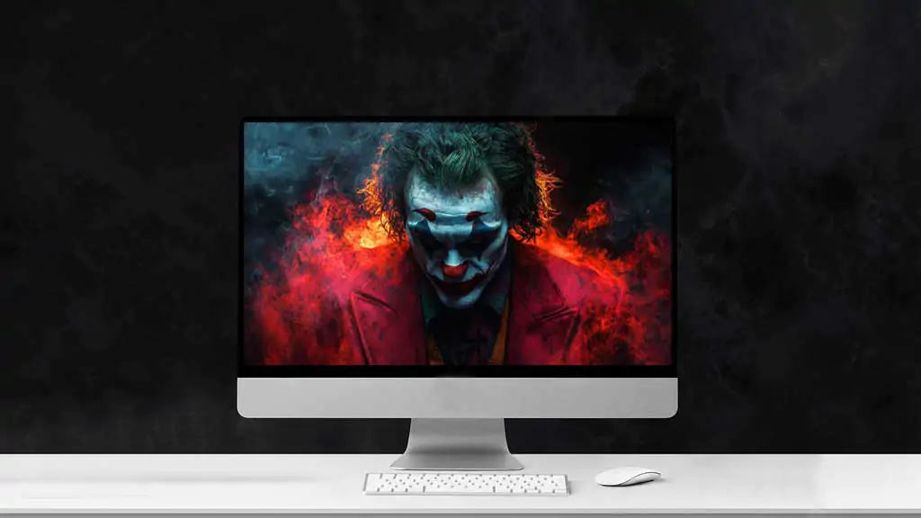 Joaquin Phoenix Joker wallpaper with dramatic fire effects and cyan face paint against red flames background, available in HD and 4K resolution