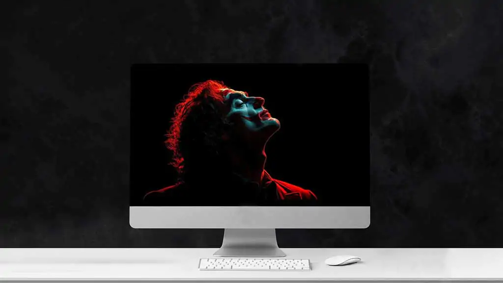 Artistic dramatic portrait Joker wallpaper 4K with red rim lighting against black background, high resolution digital art for desktop and mobile