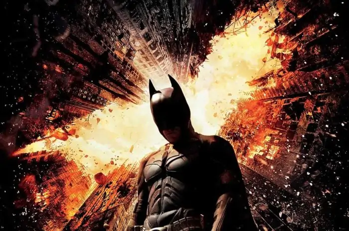 Batman The Dark Knight Rises 4K wallpaper showing hero against exploding Gotham City skyscrapers Ultra HD background Free Download