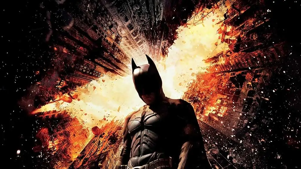 Batman The Dark Knight Rises 4K wallpaper showing hero against exploding Gotham City skyscrapers Ultra HD background Free Download