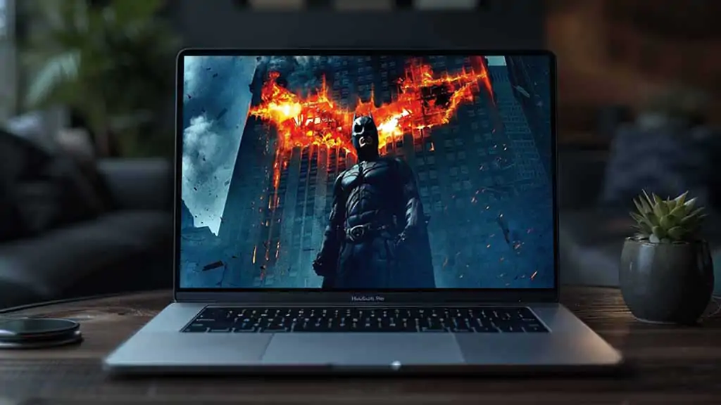 Batman The Dark Knight 4K wallpaper showing hero with giant flaming bat logo on Gotham building Ultra HD background free download