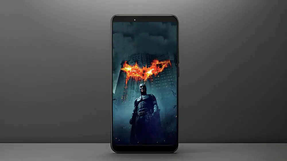 Batman The Dark Knight 4K wallpaper showing hero with giant flaming bat logo on Gotham building Ultra HD background free download