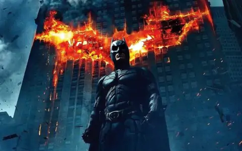 Batman The Dark Knight 4K wallpaper showing hero with giant flaming bat logo on Gotham building Ultra HD background free download
